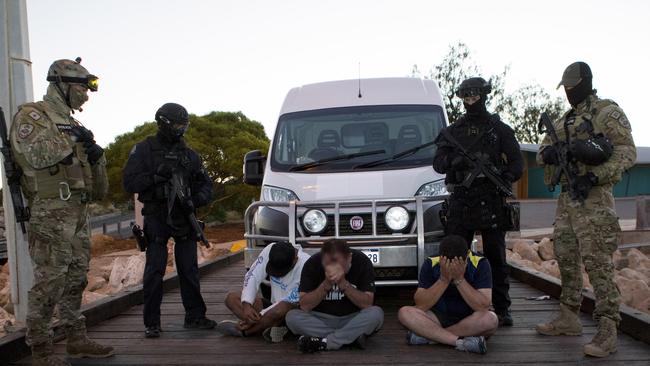 Heavily armed police stand over suspects after a sting they allege netted $1 billion worth of drugs bound for the east coast.