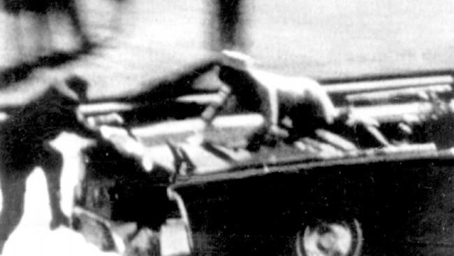 Jackie is seen climbing on the presidential car after the shooting.