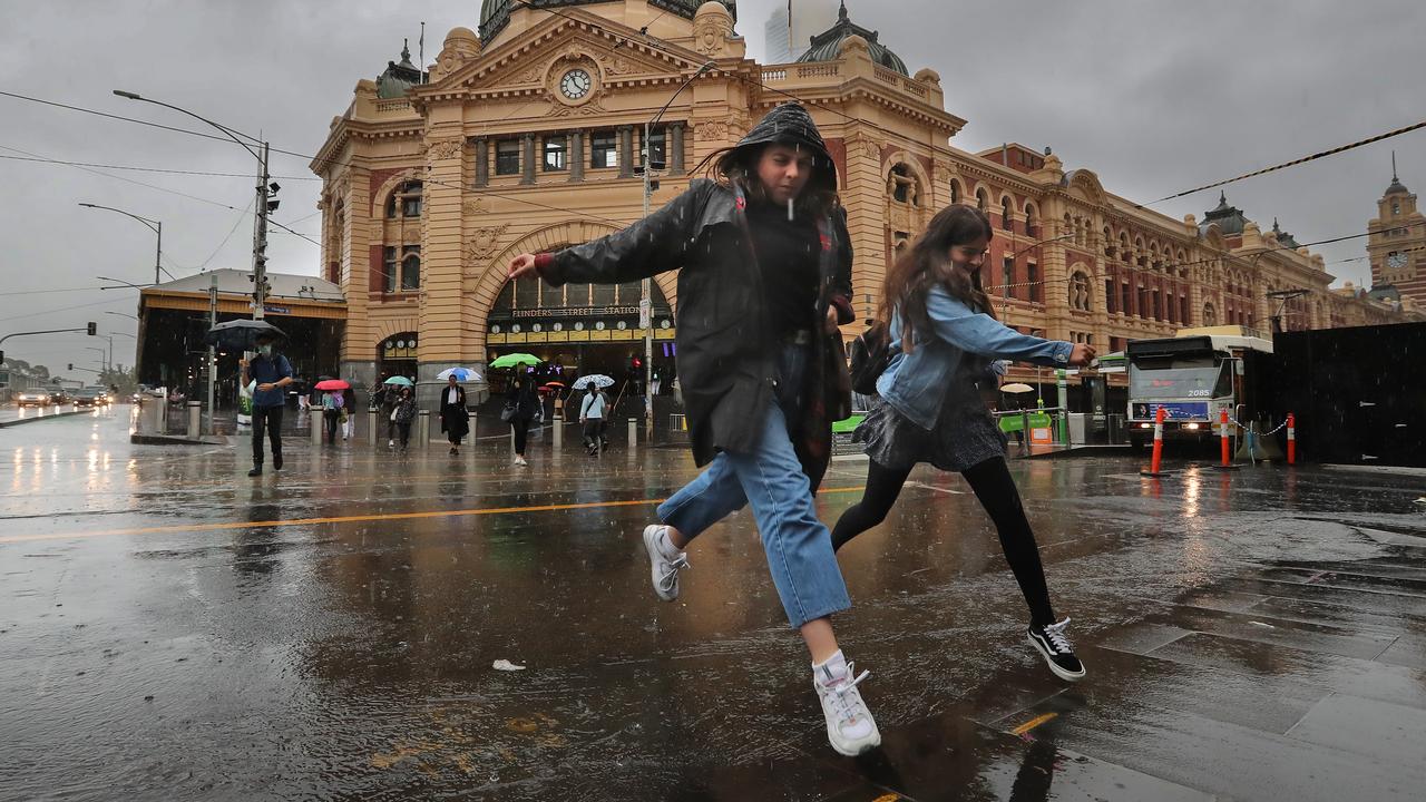 Pedestrians avoid puddles at Flinders Street Station. Picture: Alex Coppel.