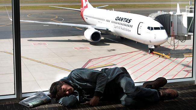  Grounded QANTAS flights at Adelaide Airport. A man sleeps as passengers wait fro the Qantas planes to take off again. 