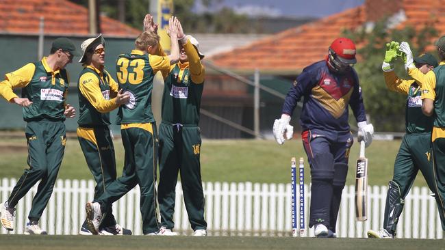 Woodville players celebrate an early wicket on Saturday with Adelaide’s Mathew Nobes being bowled. Picture: AAP Image/Dean Martin