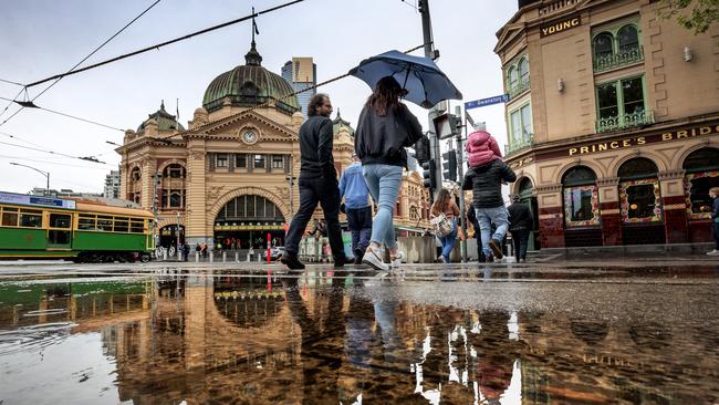 Victorians brave the rain in Melbourne’s CBD with more deluges forecast. Picture: David Geraghty