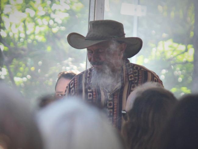 Uncle Mark Flanders walks through the crowd during a smoking ceremony at Australia Day 2021. Photo: Tim Jarrett