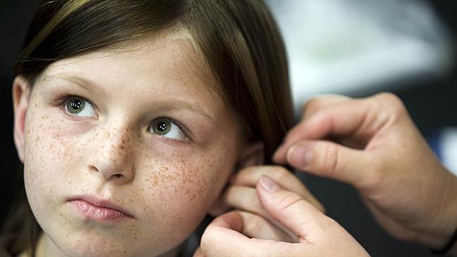  10/05/2010 WIRE: FILE -This May 2010 file photo shows Zahra Clare Baker, 10, getting a hearing aid during an event at Charlo...