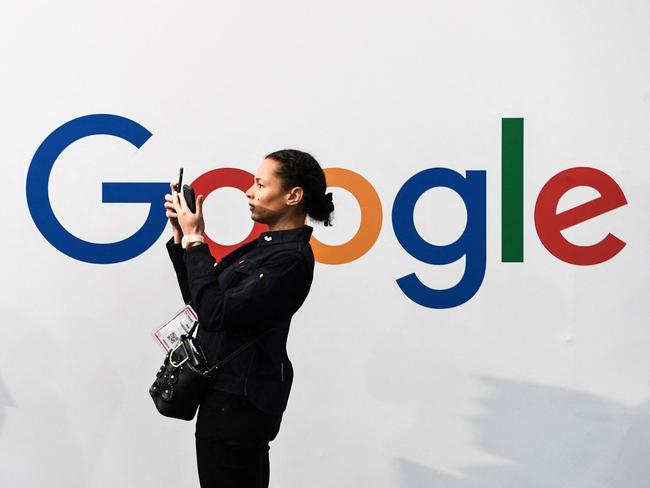 (FILES) In this file photo a woman takes a picture with two smartphones in front of the logo of the US multinational technology and Internet-related services company Google as she visits the Vivatech startups and innovation fair, in Paris on May 16, 2019. - Google has agreed to make "significant payments" to Rupert Murdoch's News Corp. for content, the companies said on February 17, 2021 as tech firms face growing pressure to pay for news from an Australian-led initiative. (Photo by ALAIN JOCARD / AFP)