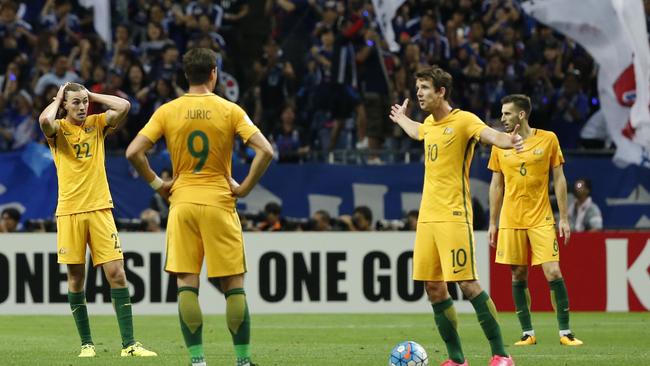 Australia's team players react after Japan scored.