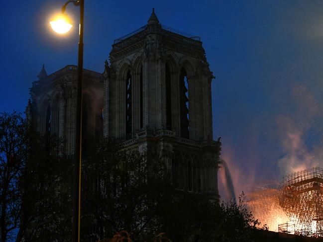 Flames are seen through the scaffolding of the Notre-Dame de Paris Cathedral during a fire on April 15, 2019, in the French capital Paris. - A huge fire swept through the roof of the famed Notre-Dame Cathedral in central Paris on April 15, 2019, sending flames and huge clouds of grey smoke billowing into the sky. The flames and smoke plumed from the spire and roof of the gothic cathedral, visited by millions of people a year. A spokesman for the cathedral told AFP that the wooden structure supporting the roof was being gutted by the blaze. (Photo by STEPHANE DE SAKUTIN / AFP)
