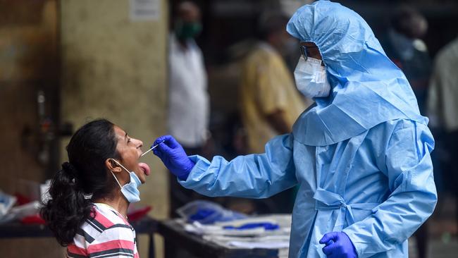 A health worker takes a swab sample from a resident getting tested for the COVID-19 near residential buildings in Mumbai on Thursday. Picture: AFP