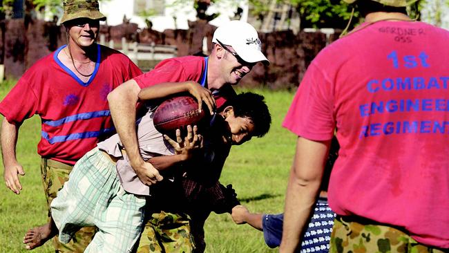 FEBRUARY 9, 2005 : Members of the 1st Combat Engineer Regiment (Darwin) teach the local children how to play AFL prior to a game of soccer between a local Banda Aceh team & the engineers, 09/02/05. Australian Defence Force (ADF) personnel are assisting Indonesian Government authorities as part of the Australian Government program of humanitarian relief following the Boxing Day tsunami. Pic Department Of Defence. Armed Forces Indonesia / Disaster / Earthquake