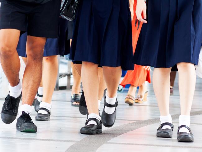 Capture of feet and shoes of students in school uniform and leaving shopping mall and walking over pedestrian bridge.