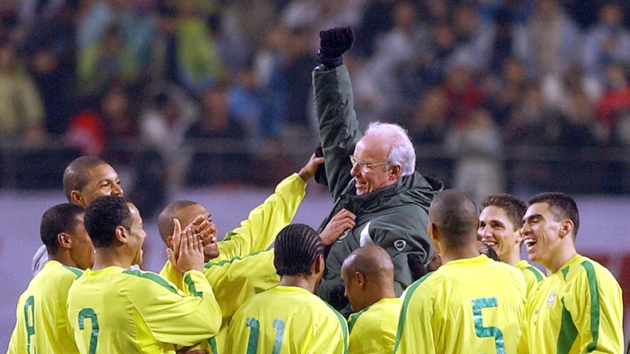 Brazilian players lift Zagallo. Photo by KIM JAE-HWAN / AFP