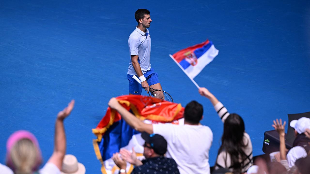 Serbia's Novak Djokovic reacts past supporters waving flags of Serbia as he plays against Italy's Jannik Sinner. Picture: William West/AFP.