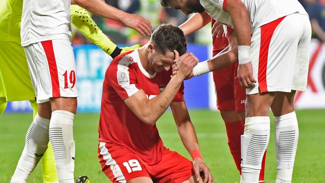 Mahmoud Wadi is consoled by Jordan's players.