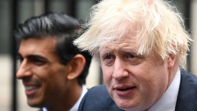 Boris Johnson (R) stands with Rishi Sunak.