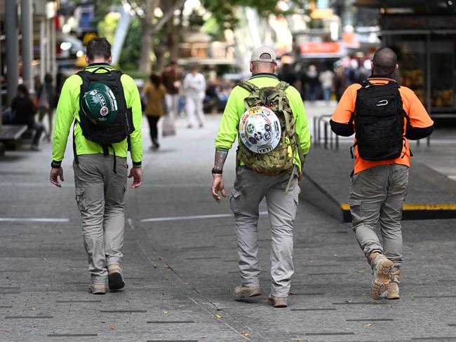 BRISBANE, AUSTRALIA - NewsWire Photos - AUGUST 31, 2022.Construction workers walk through Brisbane's CBD at the end of their work day. Queensland Education Minister Grace Grace has announced a new $10 million pilot program to boost the number of industrial technology and design (ITD) teachers, which will support tradies to become teachers in state schools.Picture: NCA NewsWire / Dan Peled
