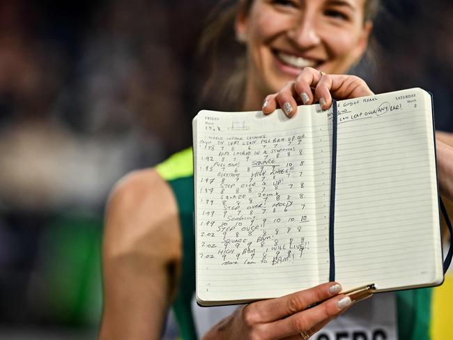 First-placed Australia's Nicola Olyslagers shows her notes as she celebrates after competing in the Women's High Jump final during the Indoor World Athletics Championships in Glasgow, Scotland, on March 1, 2024. (Photo by Ben Stansall / AFP)