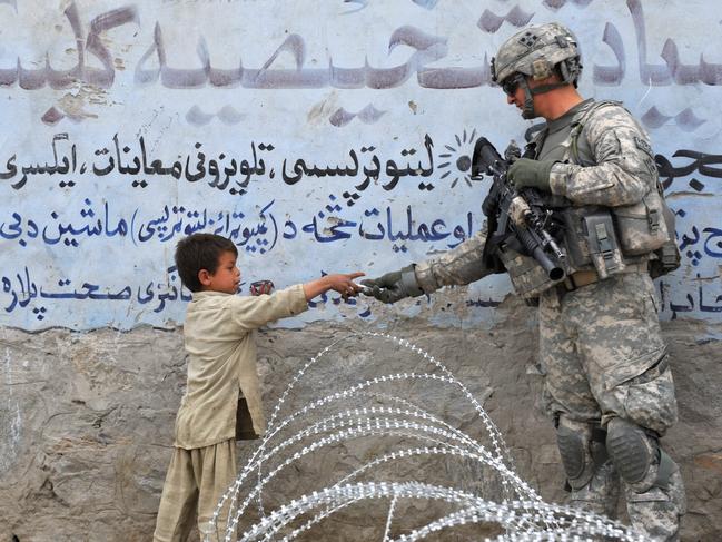 A US soldier from 4th Infantry Division 4 Brigade Alpha Company presents a gift to an Afghan child during a patrol at Khogiani in Langarhar. Picture: AFP