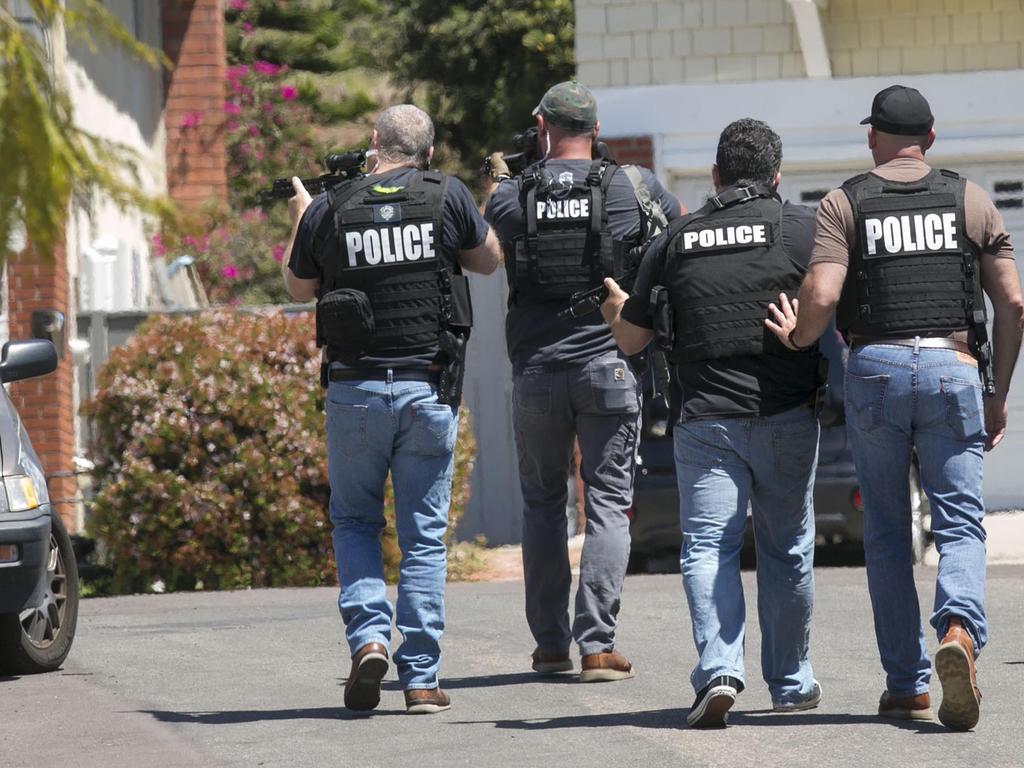 Heavily armed San Diego police officers approach a house thought to be the home of John T. Earnest. Picture: AP