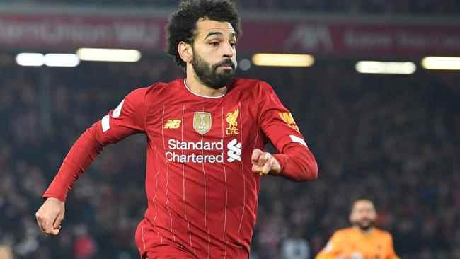 Liverpool's Egyptian midfielder Mohamed Salah (L) runs on to a through ball during the English Premier League football match between Liverpool and Wolverhampton Wanderers at Anfield in Liverpool, north west England, on December 29, 2019. (Photo by Paul ELLIS / AFP) / RESTRICTED TO EDITORIAL USE. No use with unauthorized audio, video, data, fixture lists, club/league logos or 'live' services. Online in-match use limited to 120 images. An additional 40 images may be used in extra time. No video emulation. Social media in-match use limited to 120 images. An additional 40 images may be used in extra time. No use in betting publications, games or single club/league/player publications. /