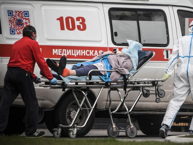 Medical workers transport a woman into a hospital where patients infected with the COVID-19 novel coronavirus are being treated in the settlement of Kommunarka outside Moscow. Picture: Alexander Nemenov