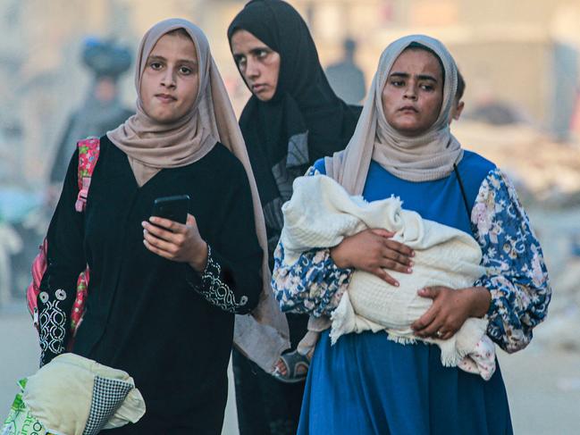 A woman holds a baby wrapped in a blanket as displaced Palestinians leave an area in east Khan Yunis after the Israeli army issued a new evacuation order for parts of the city and Rafah. Picture: Bashar TALEB / AFP