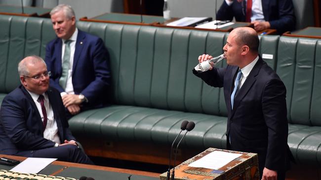 The Treasurer swigs from a bottle of water as he updates the House of Representatives on the state of the nation’s finances after a coughing fit. Picture: Getty Images