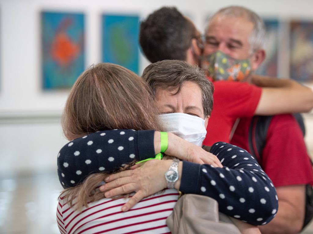 Zsofi Nemeth hugs mum Julianna Nemeth in front of Rudolf Nemeth hugs son-in-law David Kaity at Brisbane International airport as borders re-open. Picture: Brad Fleet