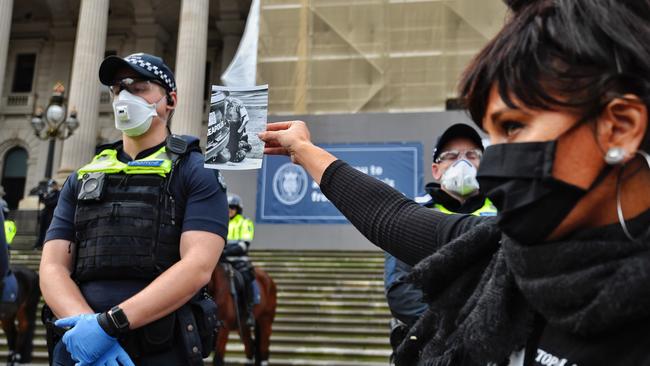 A woman holds up an image of police officer Derek Chauvin kneeling on George Floyd’s neck. Picture: Jason Edwards