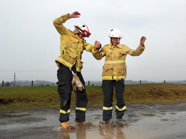 Milton RFS volunteers Glenn Patterson and Tess Oss-Emer celebrating as the rain starts to fall after six weeks of fighting fires. Picture: Jonathan Ng