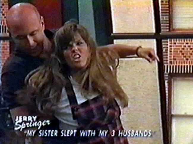 Visitor on "Jerry Springer" TV talk show restrained by security guard. Undated.