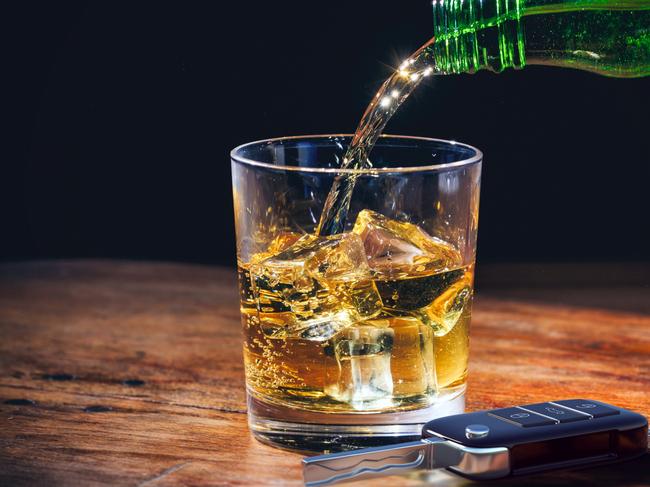 Drinking and driving concept. Car key and whiskey  glass and bottle on a wooden bar counter background. 3d illustration. Picture: iStock/Rawf8