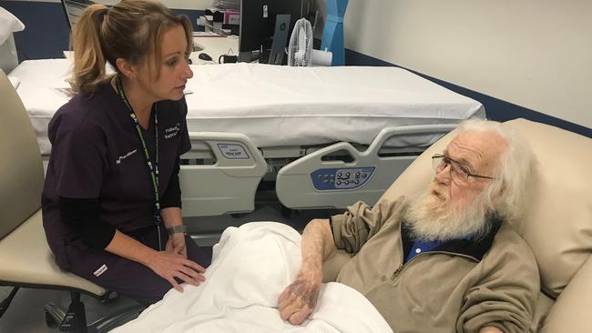 Palliative care nurse practitioner Kate Reed with patient Denis McKay, 78, receiving outpatient symptom management at The Canberra Hospital.