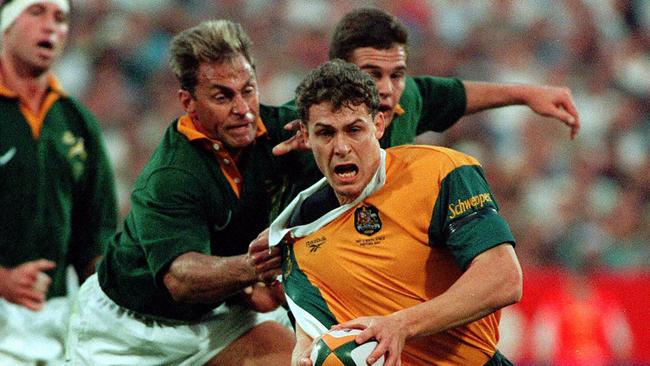 Jason Little is grabbed by Springboks player Andre Joubert.