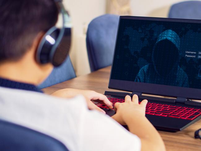 Teenage Boy In living room hacked by hacker on the table, Curious boy doing dangerous work. istock image