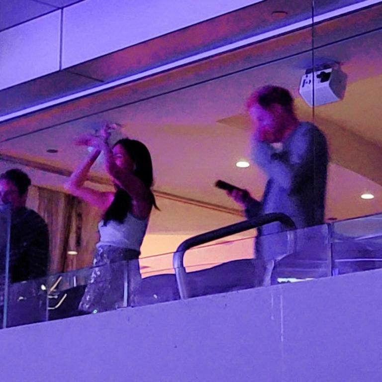 Meghan appeared to be in high spirits as she danced at the gig, while glum Prince Harry was seen checking his phone. Picture: Carrie Bardavid / twitter