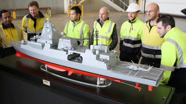 ASC workers gather around a model of the BAE-designed Future Frigate. Picture: AAP/Emma Brasier