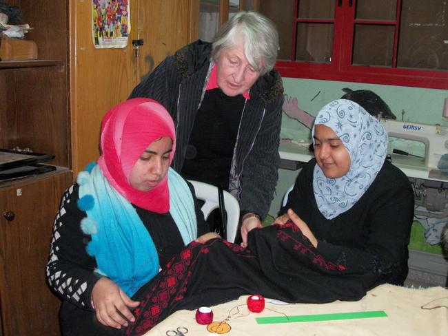 Photo 2: Dr Jean Calder AC with young women completing vocational training in embroidery.