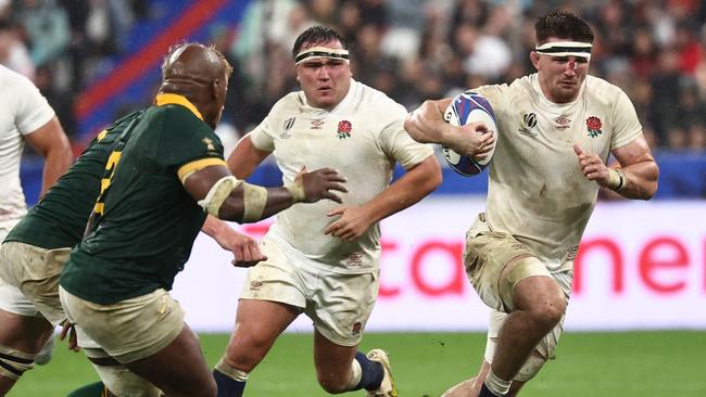 England's openside flanker Tom Curry (R) runs with the ball during the France 2023 Rugby World Cup semi-final match between England and South Africa at the Stade de France in Saint-Denis, on the outskirts of Paris, on October 21, 2023. (Photo by Anne-Christine POUJOULAT / AFP)