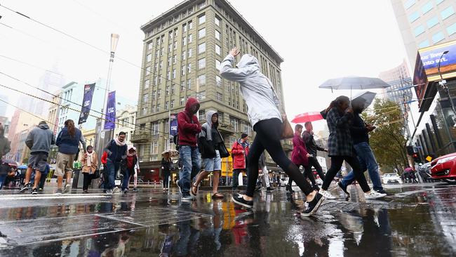 Pedestrians in the city shelter under umbrellas. Picture: Getty