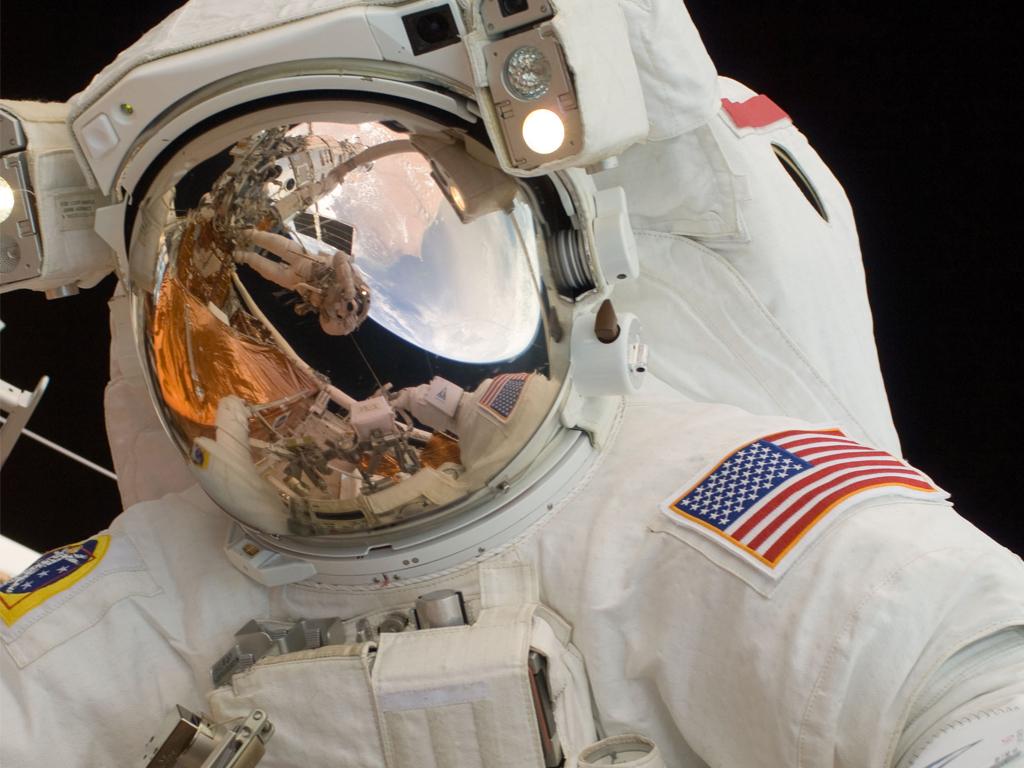 This 14 May 2009 photo provided by NASA shows astronaut John Grunsfeld performing a spacewalk to work on the Hubble Space Telescope. The reflection in his helmet visor shows astronaut Andrew Feustel taking the photo while perched on the end of the remote manipulator system arm.