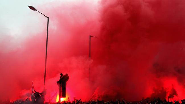 Liverpool fans light flares outside the stadium
