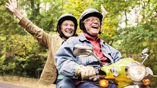 Senior couples posing for stock photos on motor scooters are happy.