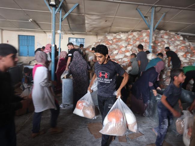 Palestinians storm a UN-run aid supply centre, that distributes food to displaced families. Picture: AFP