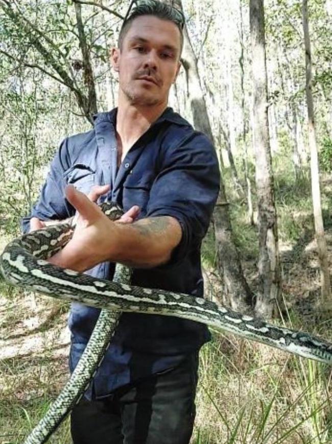 Anthony Jackson holding the five to six foot python that took over a Queensland man's bathroom. Picture: Supplied