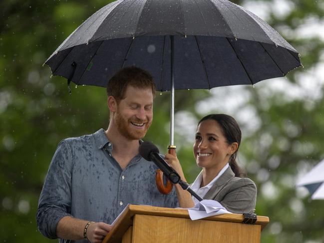 In a touching moment, Meghan held an umbrella over Harry as he gave a speech at Victoria Park in Dubbo. Picture: AP