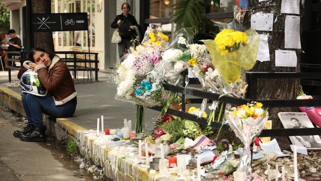 A mourner sits on the street outside the hotel. Picture: Tobias Skarlovnik/Getty Images