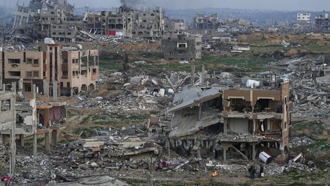 Palestinians stand beside a destroyed house in an area littered with rubble from buildings destroyed during the Israeli army's ground and air offensive against Hamas in Gaza City. Picture: AP