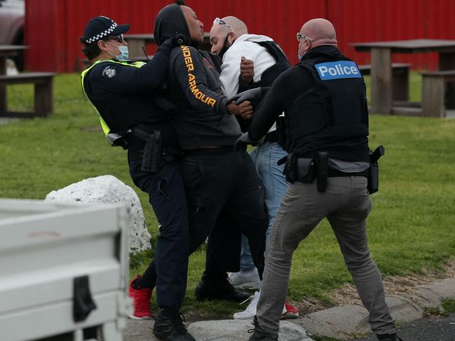 Police officers detain a demonstrator during the protest in Melbourne.