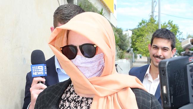 Stephanie Louise Bennett (pictured in a mask and scarf) is charged with two counts of fraud after allegedly nominating dead Sea World pilot Ash Jenkinson on a traffic infringement she received in December. Picture: NCA NewsWire / Richard Gosling