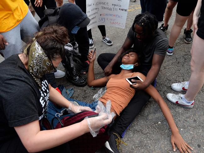 Protesters help an injured woman after clashing with police officers outside the District Four Police station during a Black Lives Matter protest in Boston, Massachusetts. Picture: AFP